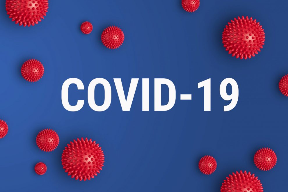 Inscription COVID-19 on blue background with red strain model of coronavirus