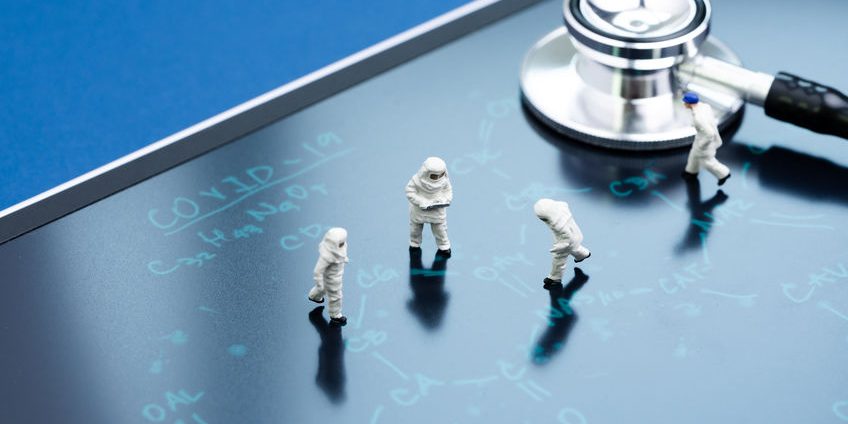 Miniature people doctors with protective suit and mask working o