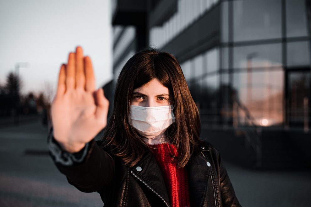 Young girl shows hand sign stop no to coronavirus epidemic pandemia originated at China. Covid-19 virus, nCov2019. Girl is against using public transport and stay home during quarantine.