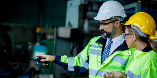 Male,And,Female,Industrial,Engineer,Explaining,The,Workplace.,He,Is